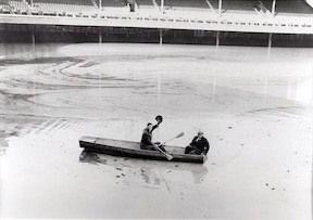 La tribune inférieure de Crosley Field est submergée sous 21 pieds d'eau. Le lanceur des Reds Lee Grissom et le secrétaire itinérant de l'équipe, John McDonald, sont entrés dans le stade par-dessus la clôture du champ gauche et ont ramé jusqu'à la zone du monticule du lanceur, 1937.